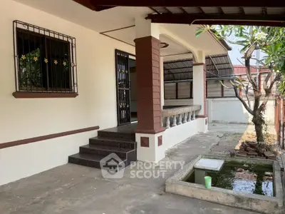 Charming home exterior with covered porch and small garden pond