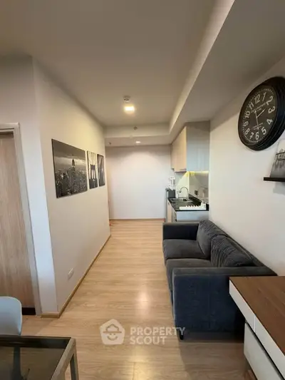 Modern living room with sleek kitchen and stylish decor in open layout apartment.