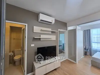 Modern apartment interior with TV, air conditioning, and stylish shelving in a cozy living space.