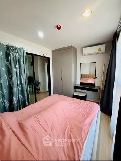 Cozy bedroom with pink bedding, air conditioning, and modern decor in a stylish apartment.