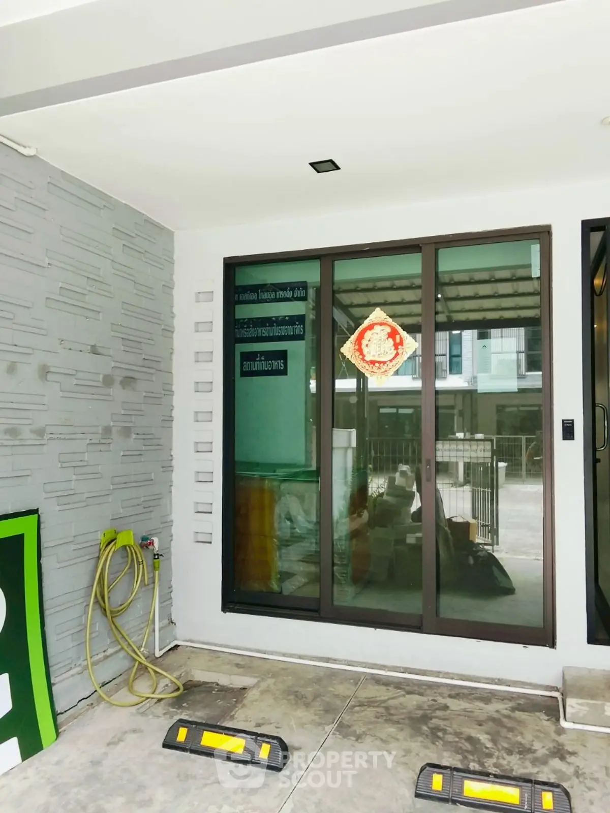 Modern entrance with sliding glass doors and decorative wall tiles