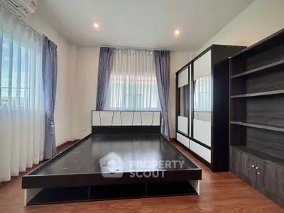 Spacious bedroom with modern furniture and large windows for natural light