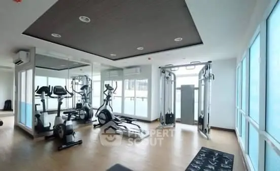 Modern gym with state-of-the-art equipment and large windows for natural light.