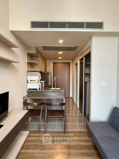 Modern open-plan living room with sleek kitchen and stylish furniture in a contemporary apartment.