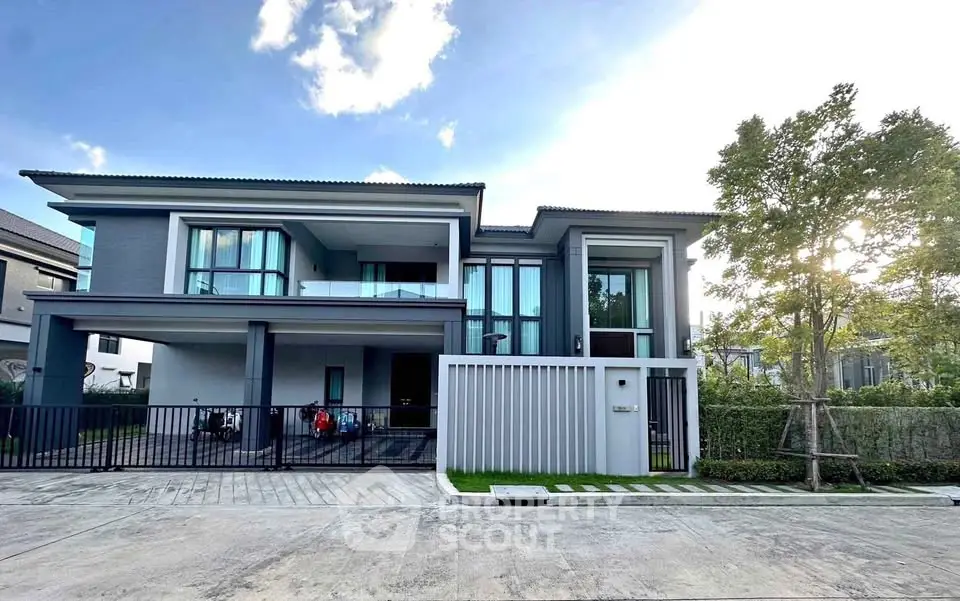 Luxurious modern two-story house with large windows and spacious driveway in a serene neighborhood.