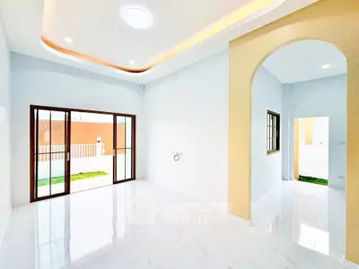 Bright and spacious interior with modern archway and sliding glass doors leading to a garden.