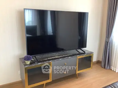 Modern living room with sleek TV stand and large flat-screen TV, perfect for entertainment.