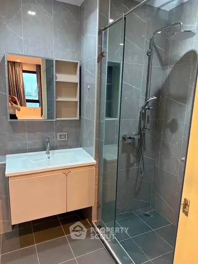 Modern bathroom with sleek shower and vanity in contemporary apartment.