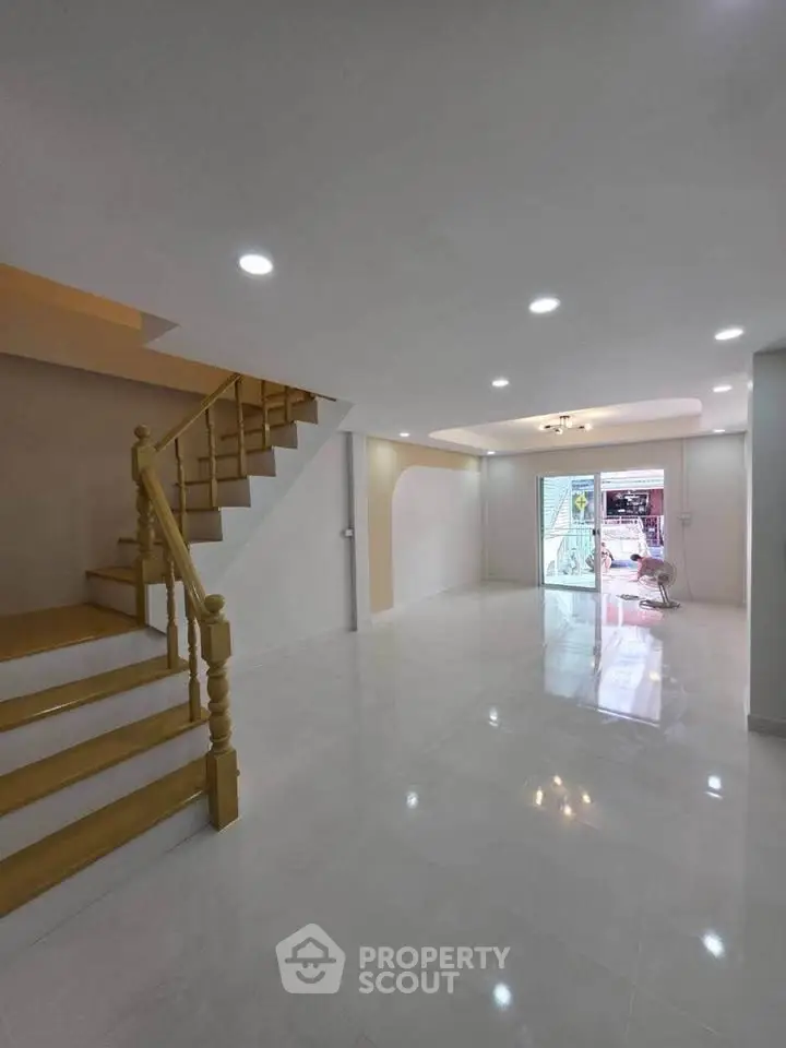 Spacious modern living room with elegant staircase and bright lighting