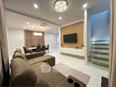 Spacious modern living room with elegant dining area and stylish staircase