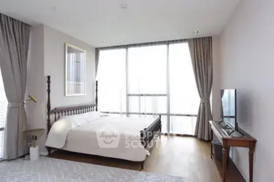 Spacious bedroom with large windows and elegant decor in modern apartment