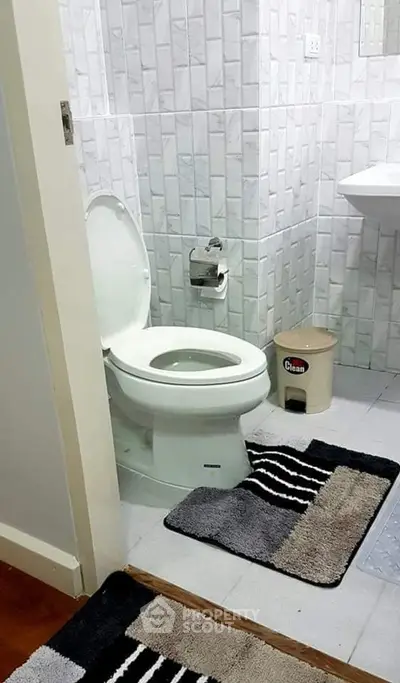 Modern bathroom with tiled walls and stylish rugs