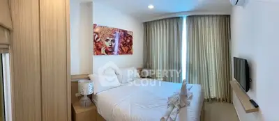 Cozy bedroom with modern decor and large window for natural light.