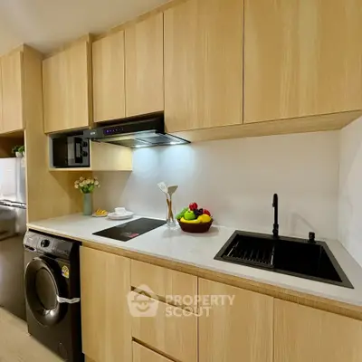 Modern kitchen with sleek wooden cabinets, built-in appliances, and elegant countertop.