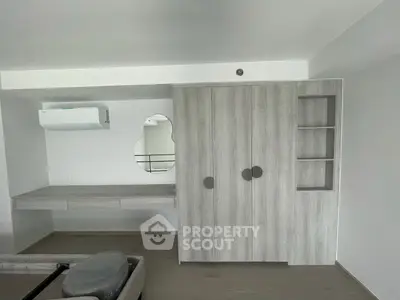 Modern minimalist bedroom with built-in wardrobe and desk, featuring sleek design and neutral tones.