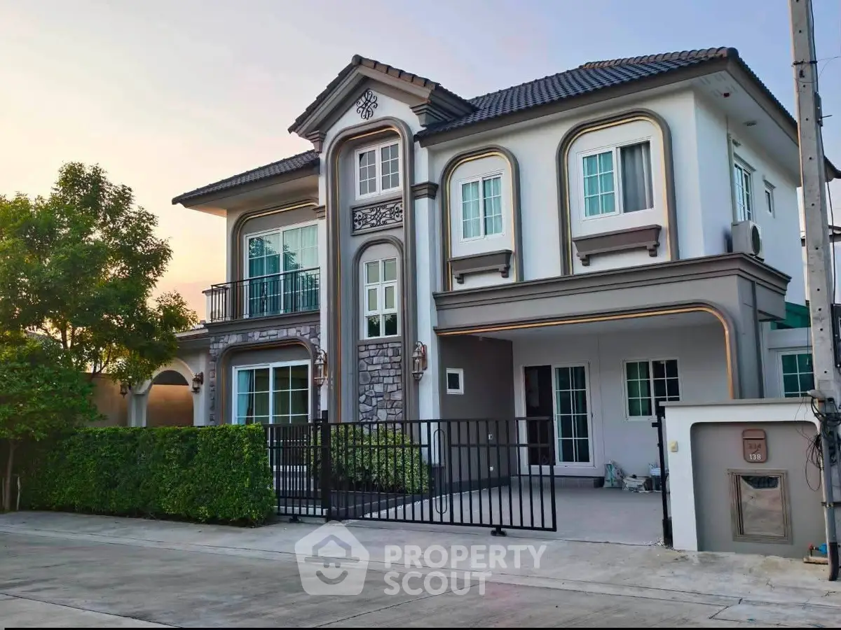 Elegant two-story house with modern design and lush greenery, perfect for family living.