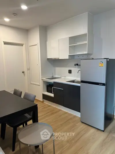 Modern kitchen with sleek appliances and dining area in stylish apartment