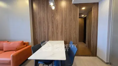Modern dining area with elegant marble table and stylish chairs in a cozy living space.