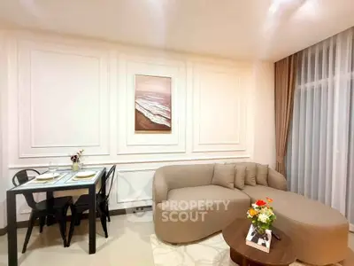 Elegant living room with modern sofa and dining area, featuring stylish decor and soft lighting.
