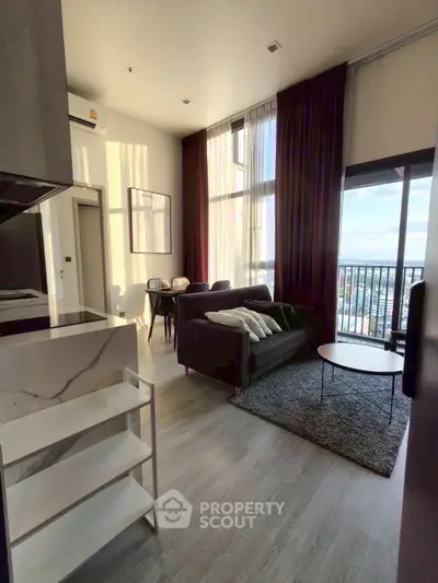Modern living room with high ceilings and large windows offering stunning city views.