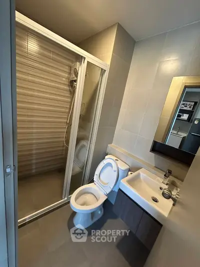 Modern bathroom with shower, toilet, and sink in sleek design