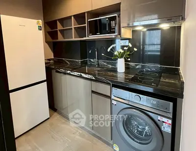 Modern kitchen with sleek appliances, marble countertops, and ample storage space.
