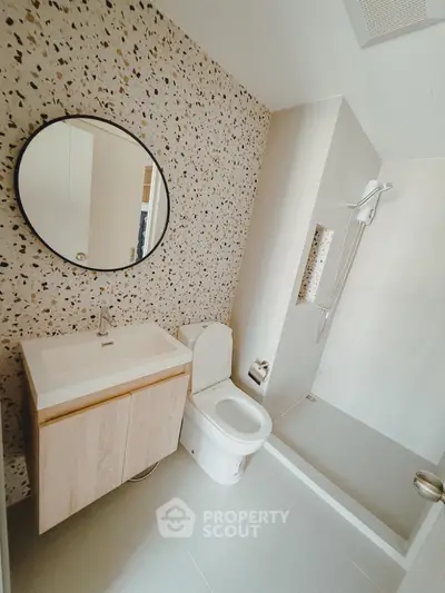Modern bathroom with terrazzo wall, sleek vanity, and walk-in shower