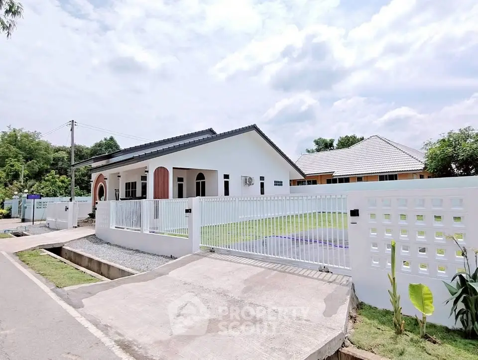 Charming modern house with spacious yard and sleek white fence in a serene neighborhood.