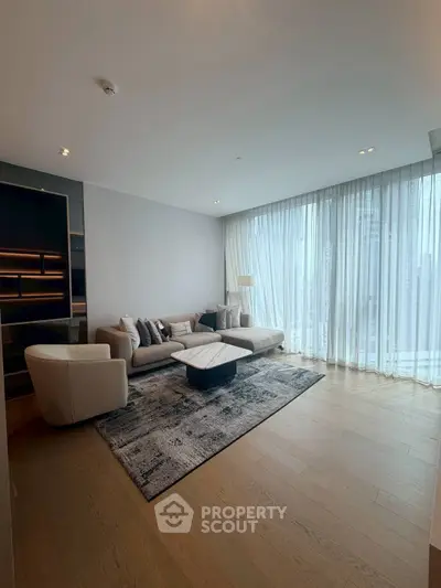 Spacious modern living room with large windows and elegant furnishings.