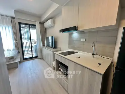 Modern studio apartment with open kitchen and balcony view