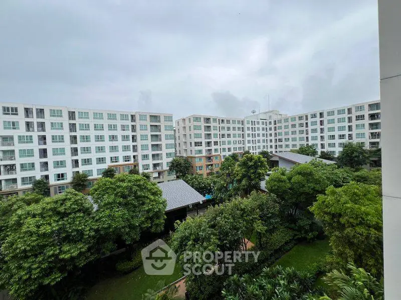 Spacious apartment complex with lush green gardens and modern architecture.
