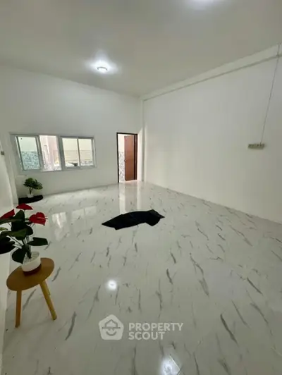 Spacious minimalist living room with marble flooring and natural light