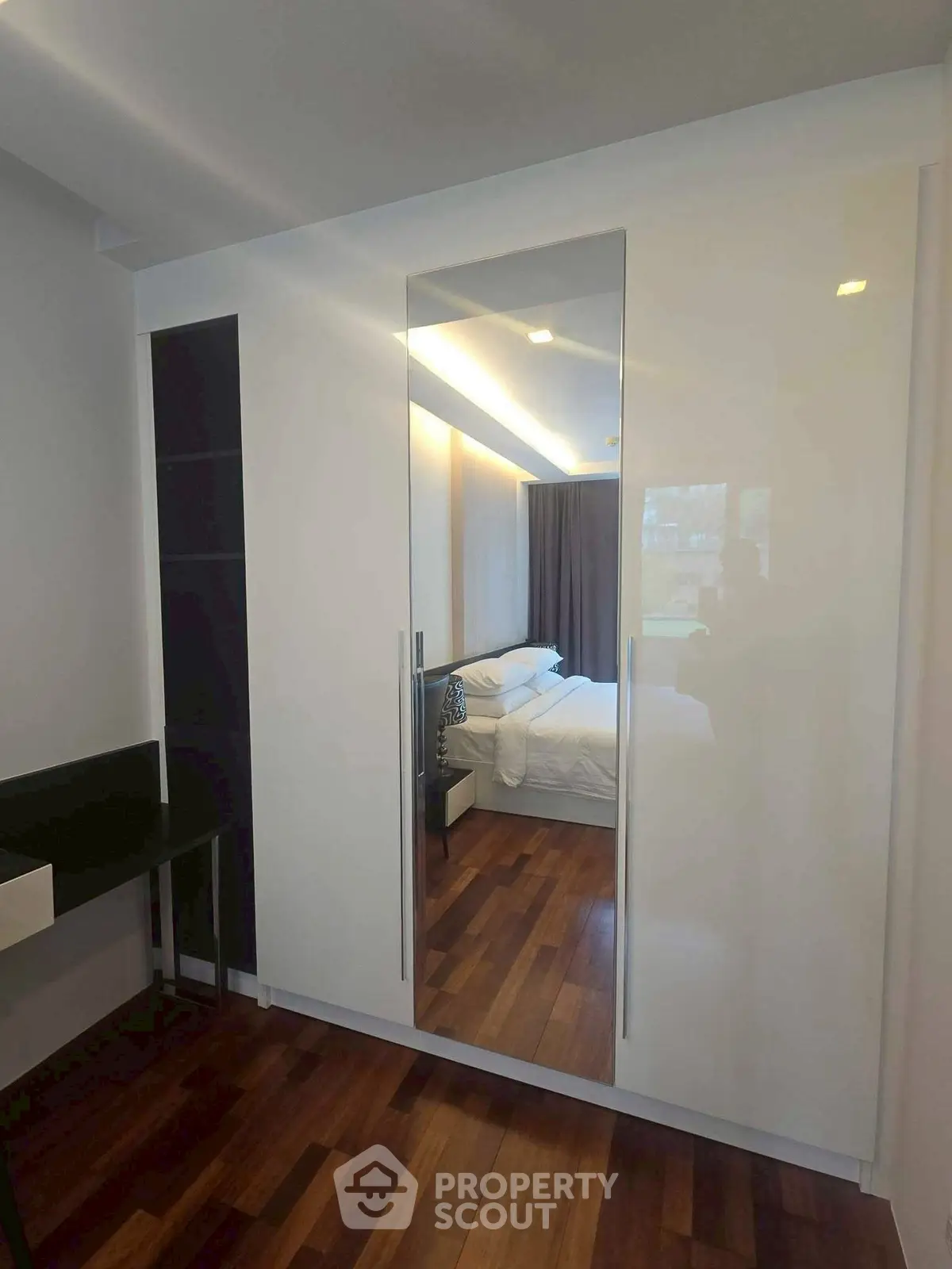 Modern bedroom with sleek wardrobe and wooden flooring