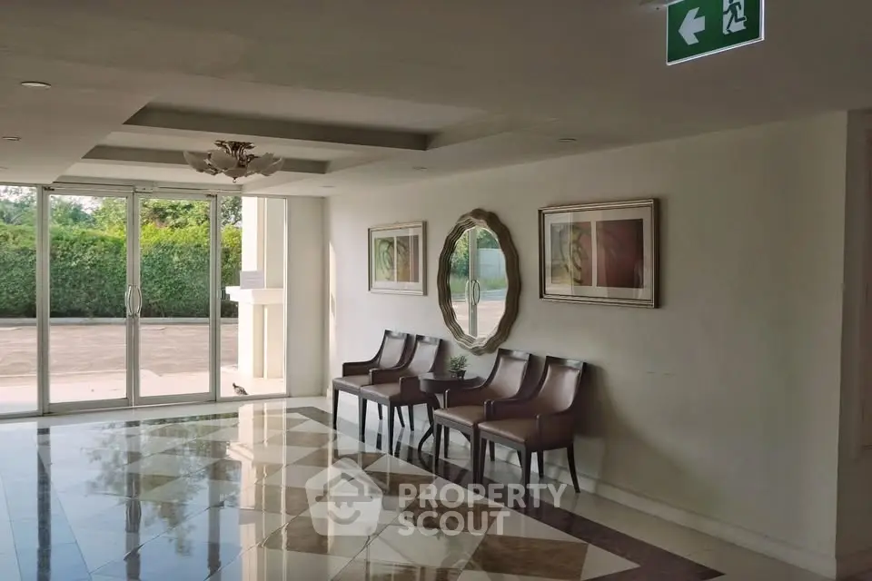 Elegant building entrance with stylish seating and decorative mirror