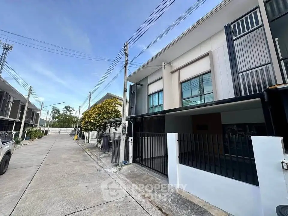 Modern townhouse exterior with gated entrance and street view