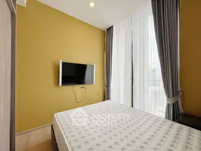 Modern bedroom with wall-mounted TV and large window with city view