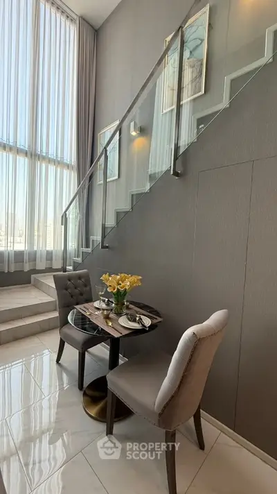 Elegant duplex interior with modern staircase and cozy dining area