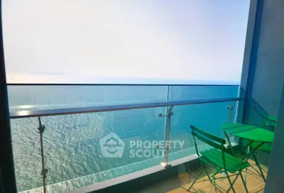 Stunning ocean view from a modern balcony with green furniture, perfect for relaxation.