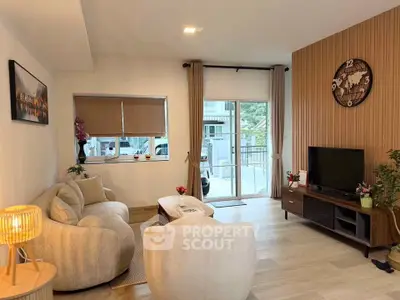 Modern living room with stylish furniture and large window offering natural light.