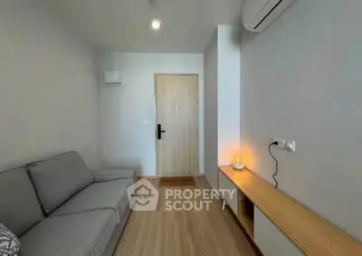 Modern living room with sleek furniture and minimalist design, featuring a cozy sofa and stylish wooden flooring.