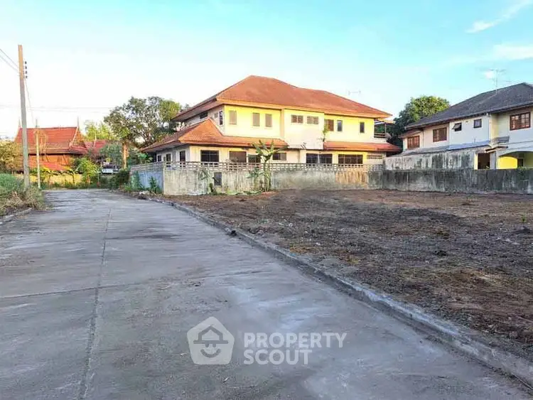 Spacious residential plot with adjacent houses in a serene neighborhood