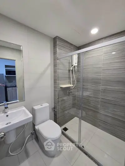 Modern bathroom with sleek shower and contemporary fixtures in a stylish apartment.