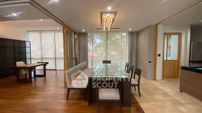 Spacious modern dining area with elegant wooden flooring and large windows offering natural light.