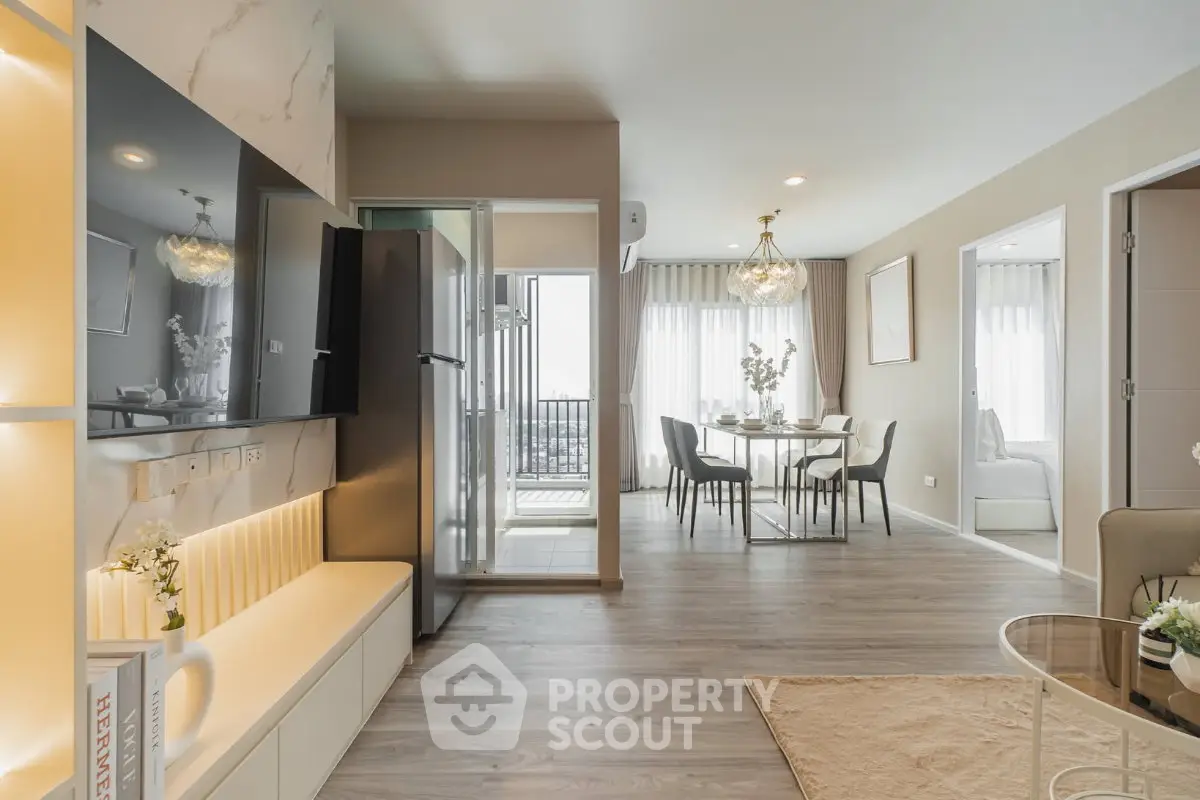 Modern open-plan living room with dining area and balcony access in a stylish apartment.