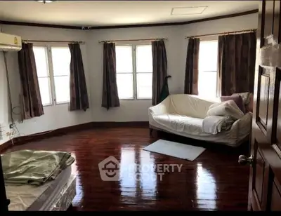 Spacious living room with polished wooden floors and natural light