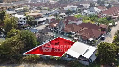 Aerial view of residential neighborhood with highlighted plot for sale, showcasing potential for development.
