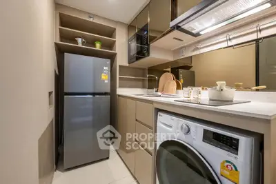 Modern kitchen with sleek appliances and washing machine in compact layout