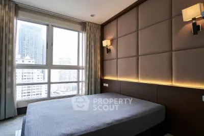 Luxurious bedroom with city view and elegant wall lighting in modern apartment.