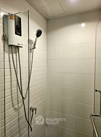 Modern bathroom with sleek shower unit and white tiled walls