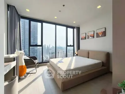Modern bedroom with large windows offering stunning city views and stylish decor.